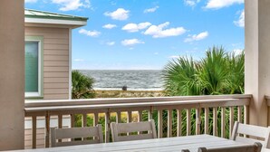 A balcony with a view of the ocean, white chairs, and a table. - 4 Bed 5 Bath Luxury Beach Front Home w/Ocean Views (Tybee Island)