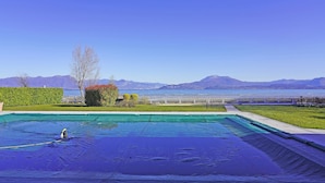 Une piscine offrant une vue sur les montagnes et un plan d’eau situé au loin.