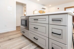A kitchenette with a built-in microwave, multiple drawers, and a countertop. - S-Turns - Loft #1 - 8 min walk to the beach (Virginia Beach)