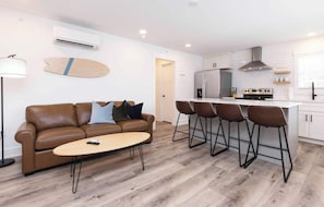 A modern apartment with a living room, a kitchen, and a dining area.