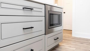 A kitchen with a built-in microwave, stainless steel cabinets, and a wooden floor. - Teahupo'o - Loft #2 - 8 min walk to the beach (Virginia Beach)