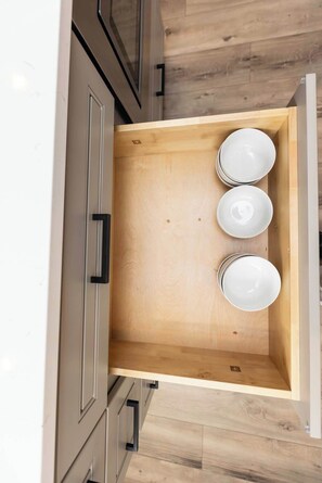 A kitchen drawer with a wooden interior, three white plates, and a handle. - Rincon - Loft #6 - 8 min walk to the beach (Virginia Beach)