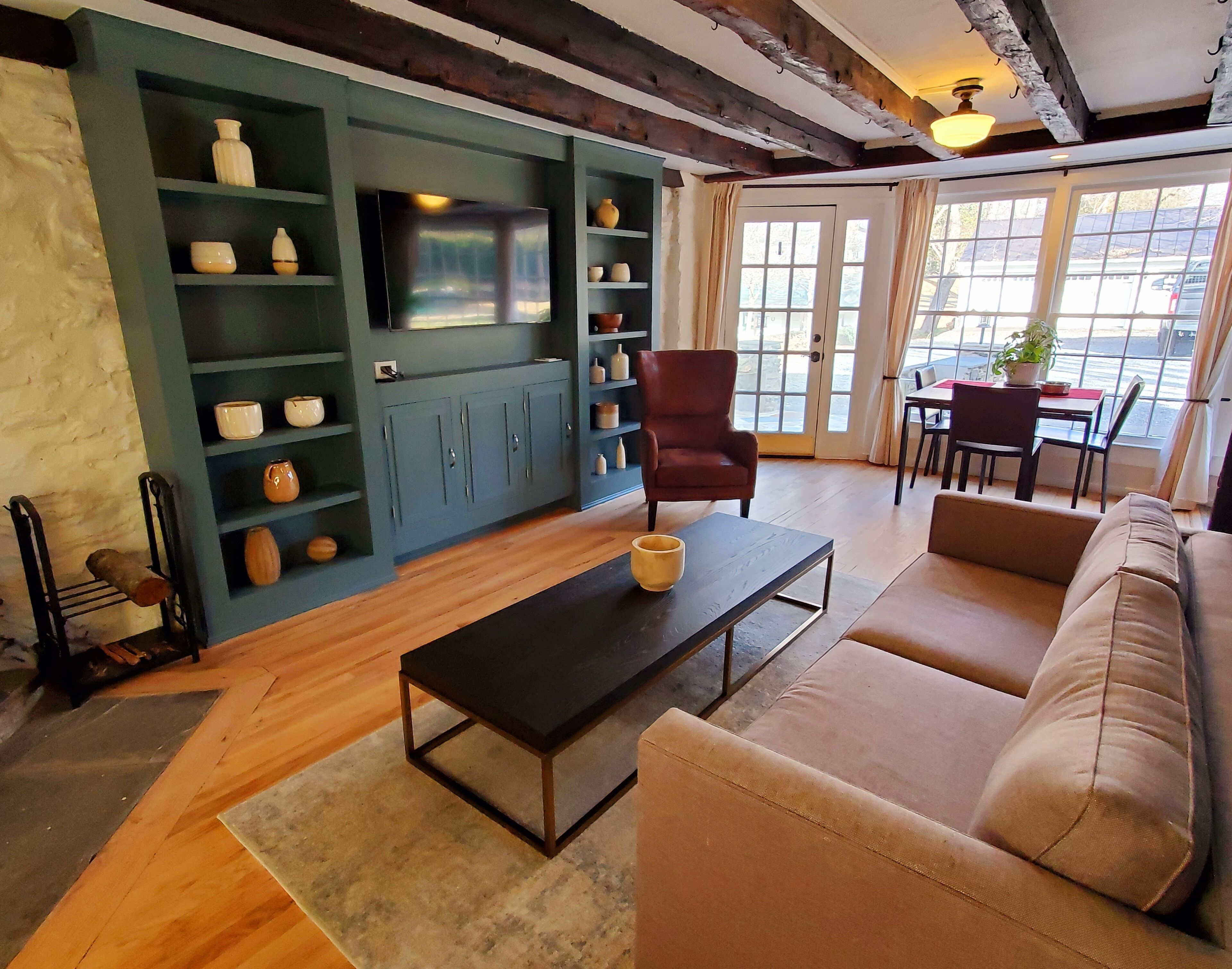 A living room with a sofa, a coffee table, a TV, and shelves with decorative items.