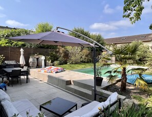 A patio with outdoor furniture, a pool, and a covered seating area. - Charmante Maison Familiale (Gradignan)