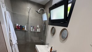 A modern bathroom with a glass-enclosed shower, a vanity with a mirror, and a toilet. - Charmante Maison Familiale (Gradignan)