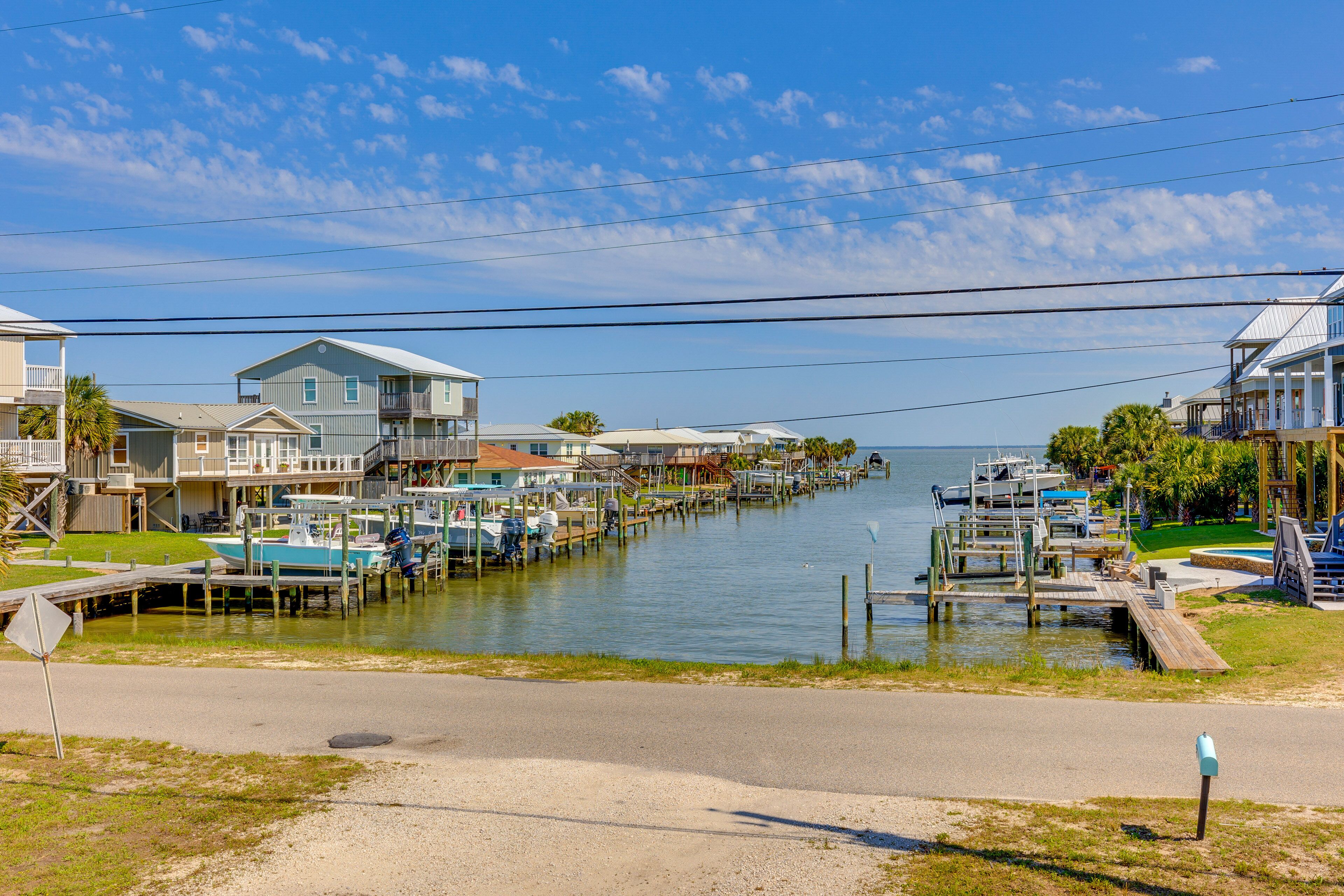 A marina with docked boats, waterfront houses, and a clear sky.