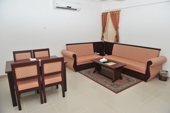 A living room with a sofa, two chairs, a coffee table, and a rug.