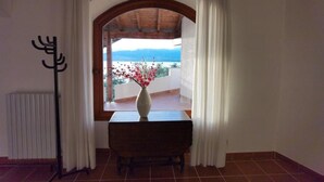 A room with a view through an arched doorway to a balcony overlooking a body of water. - Villa Schaake Lago Maggiore 100m vom Strand (Gonte)