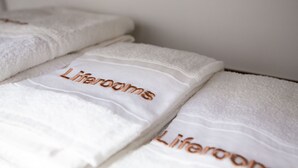 Neatly folded white towels with the text "Liferooms" embroidered in a light color. - Liferooms b&b (Ischia)