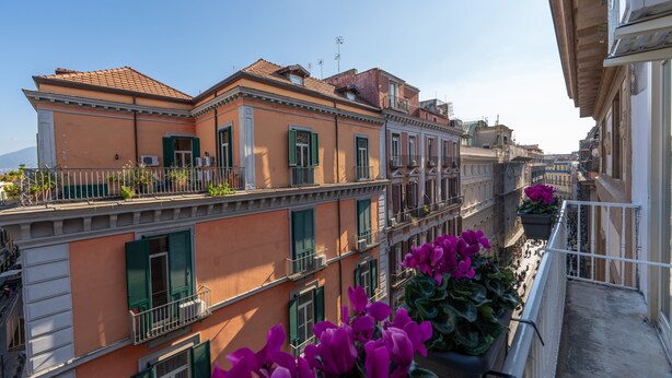 A multi-story building with balconies and a clear sky. - Teatro Toledo 272 (Naples)
