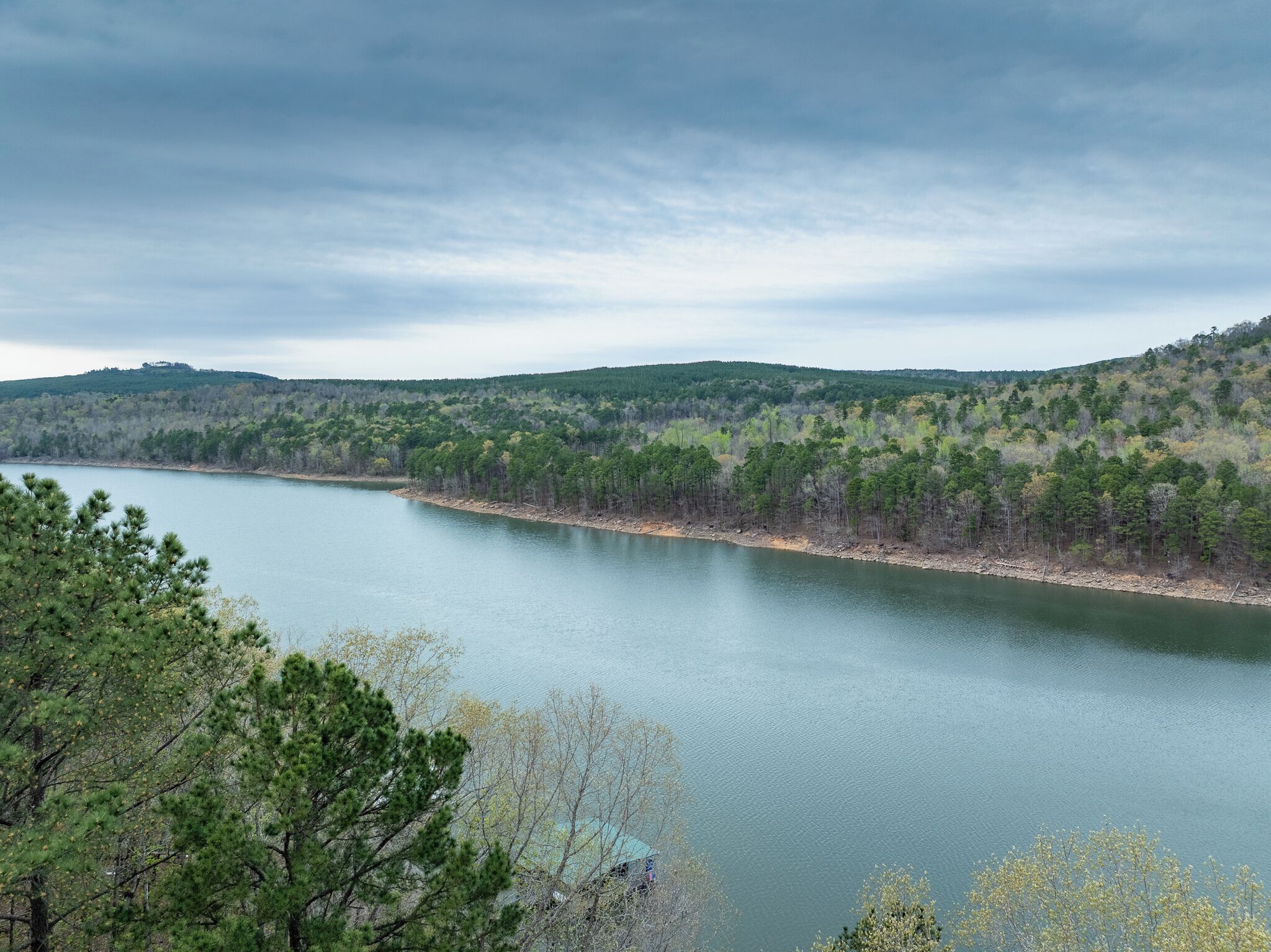 Un río rodeado de bosque denso y colinas.