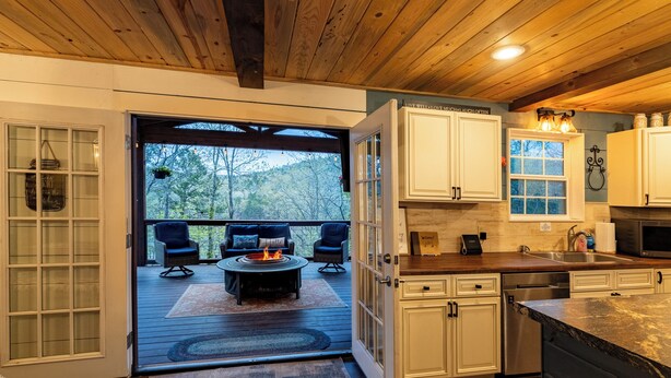 A modern kitchen with white cabinets, a wooden countertop, and a built-in oven.