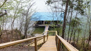 A wooden staircase leading to a blue-roofed structure by a lake.