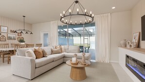 A modern living room with a sectional sofa, a wooden coffee table, and a fireplace. - Stylish 5-BR Townhouse, PVT Pool,  Just Walk to the Clubhouse! (Davenport)