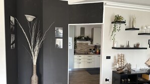 Een moderne keuken met witte kasten, een zwart aanrecht en een houten vloer.