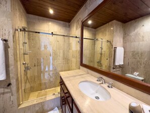 A bathroom with a glass-enclosed shower, a sink, and a large mirror. - "srvittinivillas Great / Family / Trip Team/ Caribbean Dr" (San Rafael del Yuma)