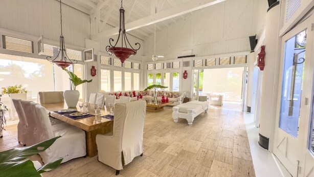 A spacious room with a high ceiling, large windows, and a dining area with a table and chairs. - "srvittinivillas Great / Family / Trip Team/ Caribbean Dr" (San Rafael del Yuma)