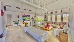 A spacious room with a large bed, a sofa, and a dining area. There are potted plants and a TV on the wall. - "srvittinivillas Great / Family / Trip Team/ Caribbean Dr" (San Rafael del Yuma)