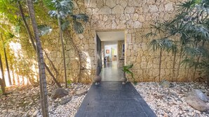 A stone pathway leading to a building entrance, surrounded by rocks and plants. - "srvittinivillas Great / Family / Trip Team/ Caribbean Dr" (San Rafael del Yuma)