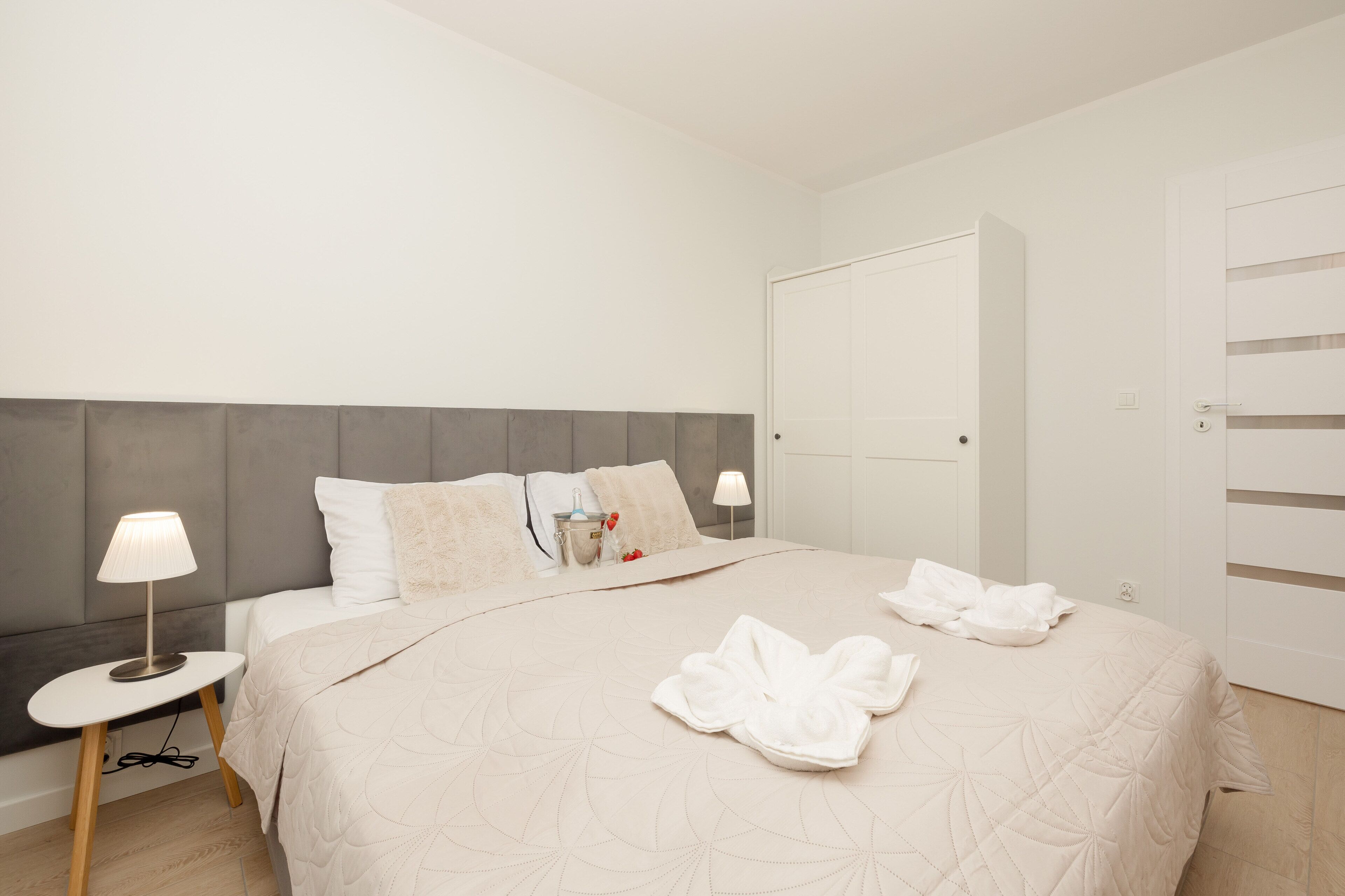 Ein Hotelzimmer mit Bett, Nachttischen, einem Schrank und einem Kleiderschrank.
