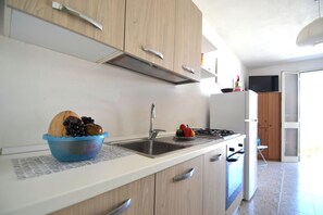 Una cocina con un lavabo, estufa y armarios.