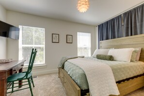 A bedroom with a bed, a desk, a chair, and a television. - 1 Mi to Downtown: Modern Ocean Springs Cottage (Ocean Springs)