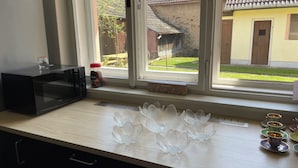 Een keukenblad met een magnetron, een Nespresso Classic koffieapparaat en een doos met de tekst 'what else?'.