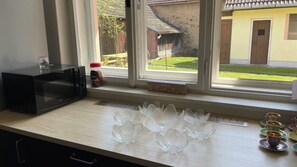 En köksbänk med en mikrovågsugn, en Nespresso-kaffemaskin och en burk med kaffekapslar.