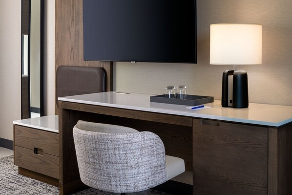 A hotel room with a desk, a chair, a flat-screen TV, a lamp, and a small table with salt and pepper shakers. - Delta Hotels by Marriott Wichita Falls Convention Center (Wichita Falls)
