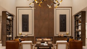 A spacious lobby with a modern chandelier, a fireplace, leather sofas, and a patterned rug. - Delta Hotels by Marriott Wichita Falls Convention Center (Wichita Falls)