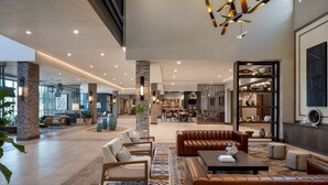 A spacious lobby with a central seating area, a bar, and a view of the kitchen. - Delta Hotels by Marriott Wichita Falls Convention Center (Wichita Falls)