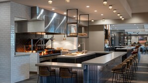 A modern kitchen with a central island, bar stools, and pendant lighting. - Delta Hotels by Marriott Wichita Falls Convention Center (Wichita Falls)