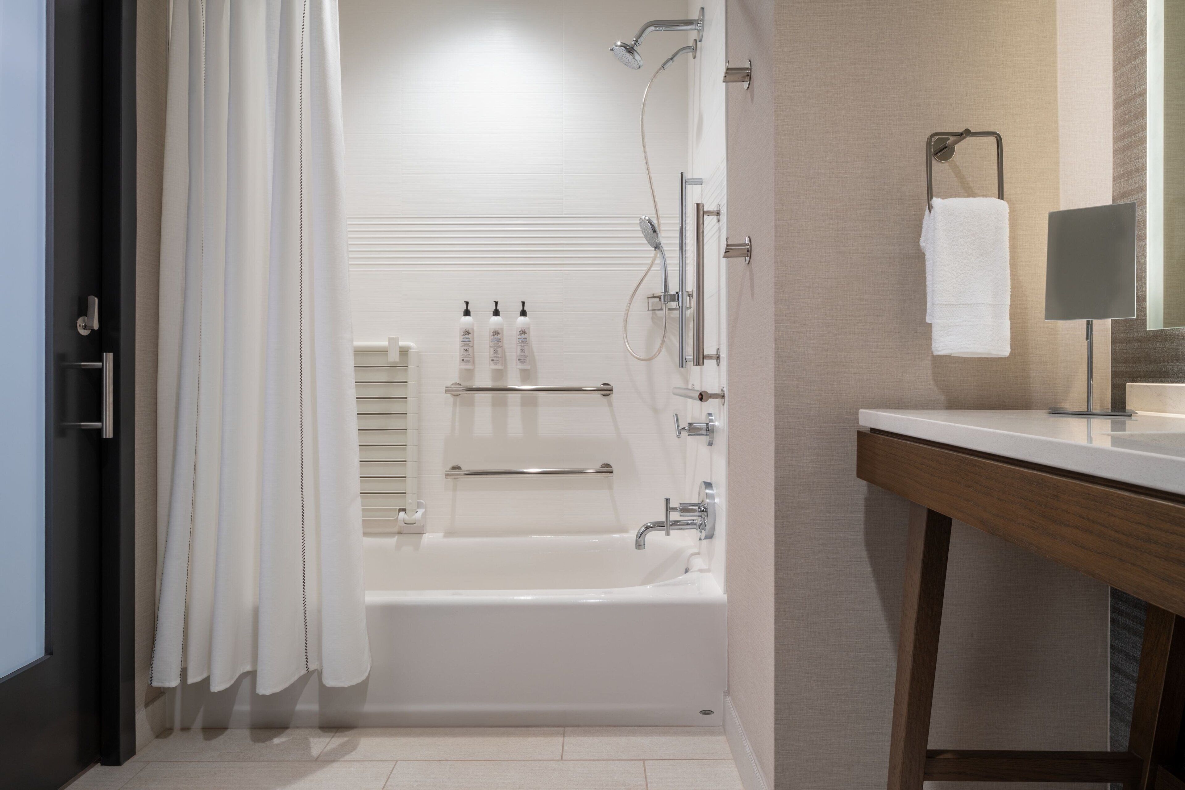 A modern bathroom with a bathtub, shower, and vanity.