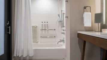 A modern bathroom with a bathtub, shower, and vanity.