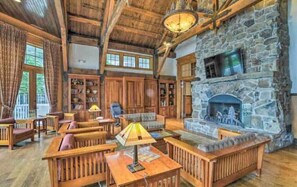 Cozy up by the fireplace in this inviting living area with a TV, bookshelves, and comfortable seating.