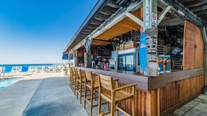 Een strandbar met houten zitplaatsen en uitzicht op zee.