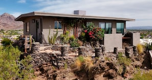 Une maison moderne avec des fondations en pierre, un toit plat et une vue sur le paysage environnant.