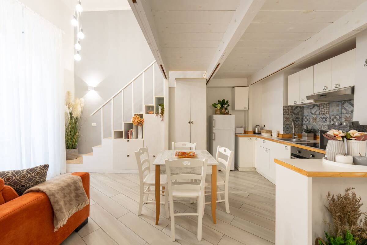 Eine moderne Küche mit weißen Schränken, einer Holz Arbeitsplatte und einem eingebauten Herd.