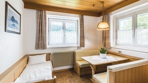 Um quarto aconchegante com um banco de madeira, uma mesa pequena e um radiador.
