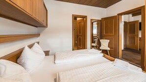 Un dormitorio con dos camas, cabeceros de madera y techo de madera.