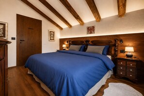Quarto com cama grande, cabeceira de madeira, mesas de cabeceira com abajures e guarda-roupa de madeira.