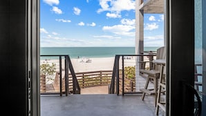 Ein Balkon mit Blick auf Strand und Meer.