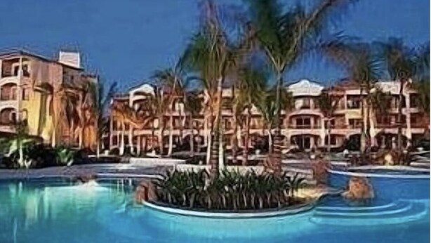A resort with a large swimming pool surrounded by palm trees and multi-story buildings. - Las Mananitas-Awesome Luxury Beachside Condo in Cabo! (San José del Cabo)