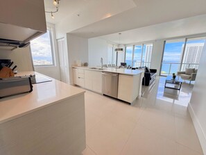 A modern kitchen with a central island, large windows, and a view of the city. - Exclusive 3 bedrooms apartment w/Amazing View (Hallandale Beach)