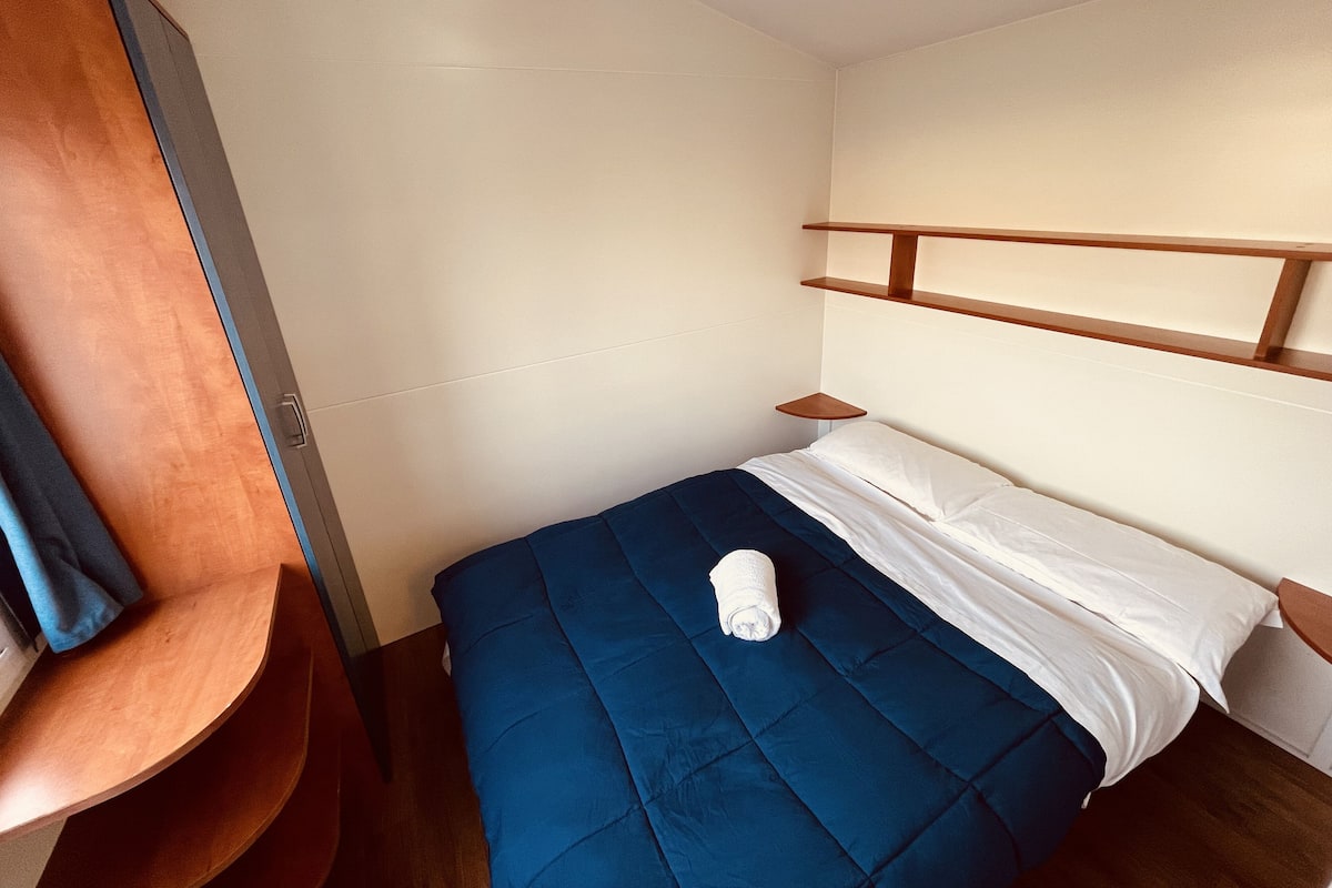Casa rodante básica | Espacio para trabajar con laptop y ropa de cama