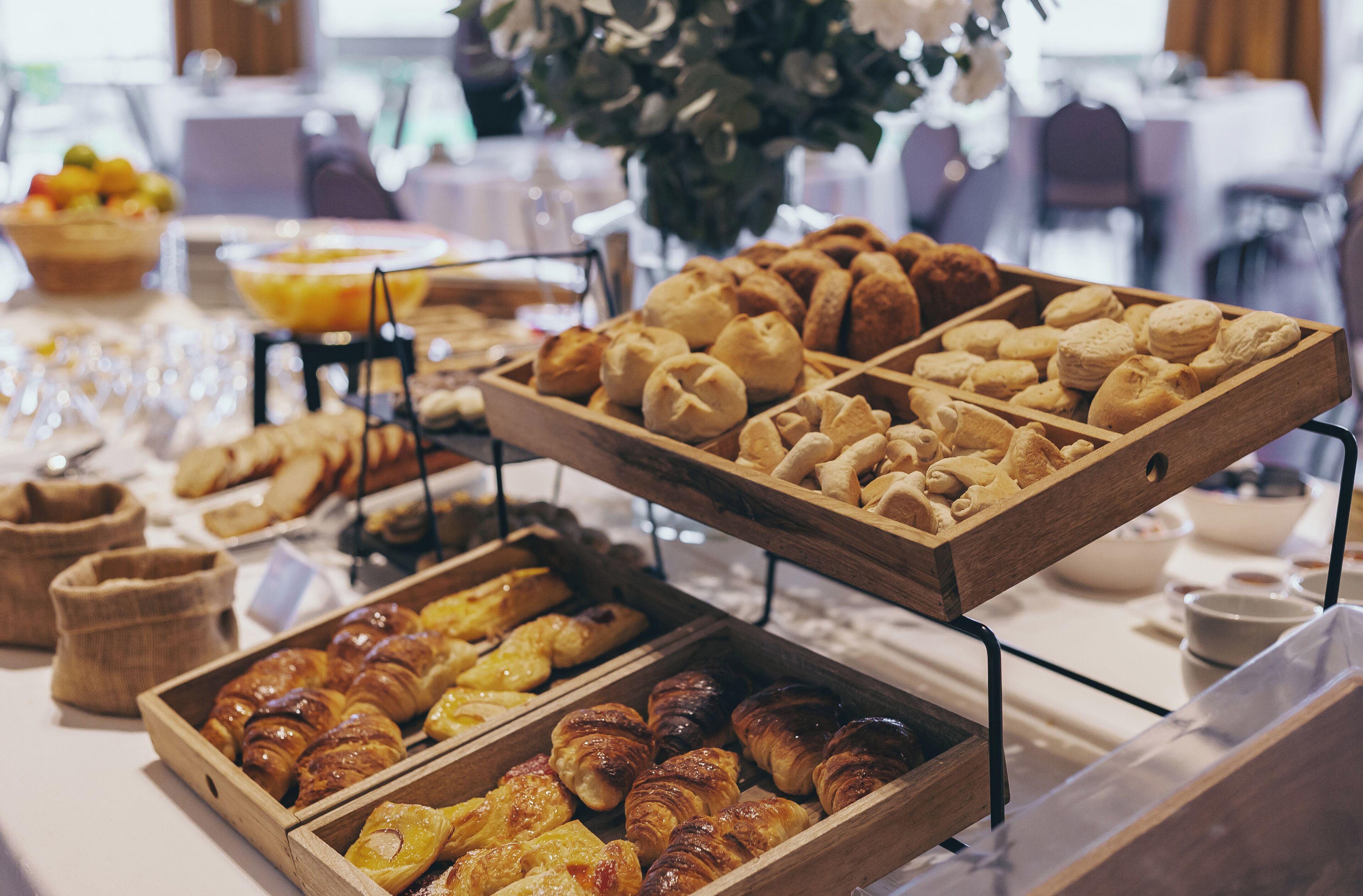 A buffet with various baked goods including pastries and bread.