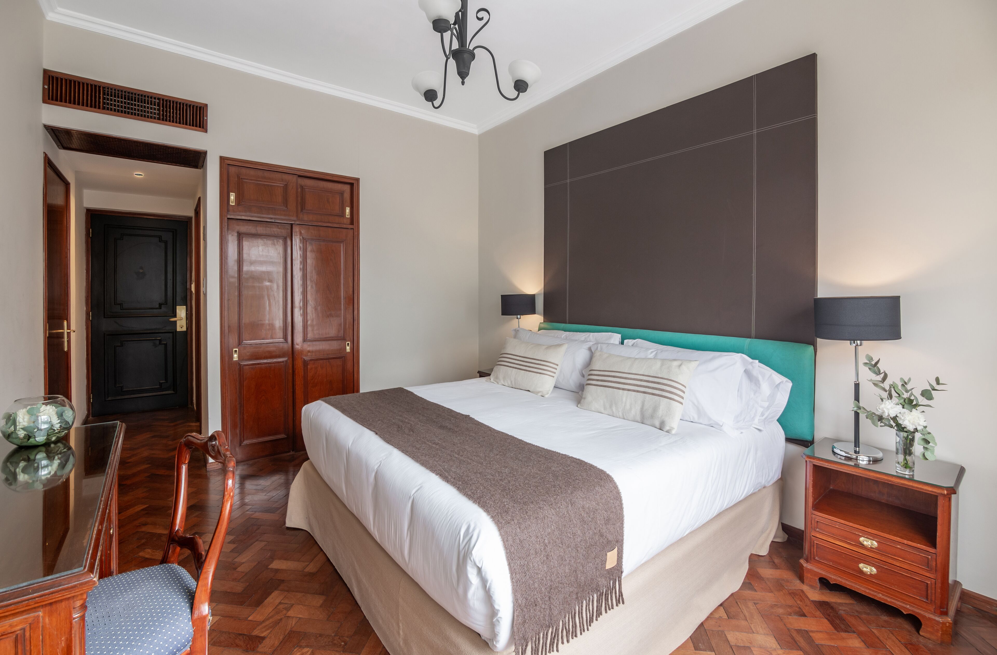 Una camera da letto con un letto grande, un'armadiatura in legno e una scrivania con una sedia.