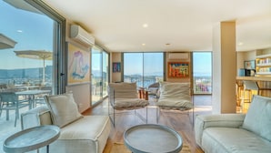 A spacious living area with a balcony, modern furniture, and a view of the city. - Olira Türkbükü Residences (Bodrum)