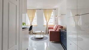 Un salon moderne avec un canapé, une table basse et un fauteuil.