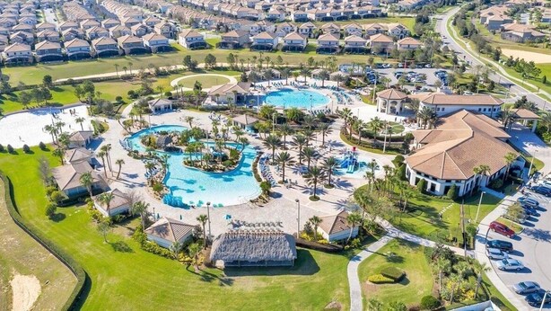 Vue aérienne d’un complexe hôtelier doté de plusieurs piscines, d’une grande piscine centrale et d’un club-house.
